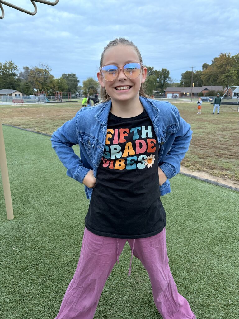 a student smiling dressed as a teacher