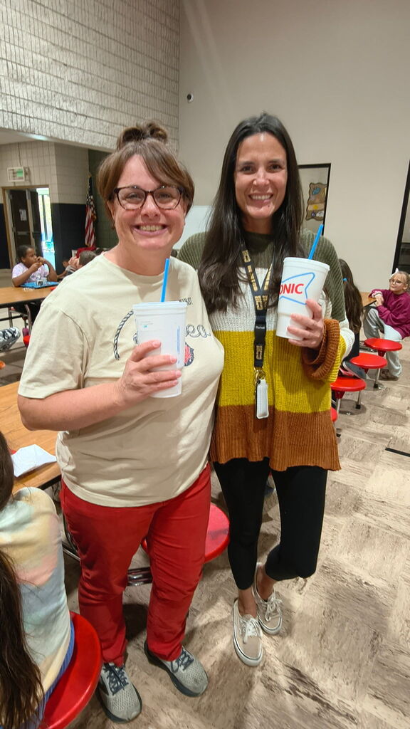 teacher holding a sonic drink, smiling