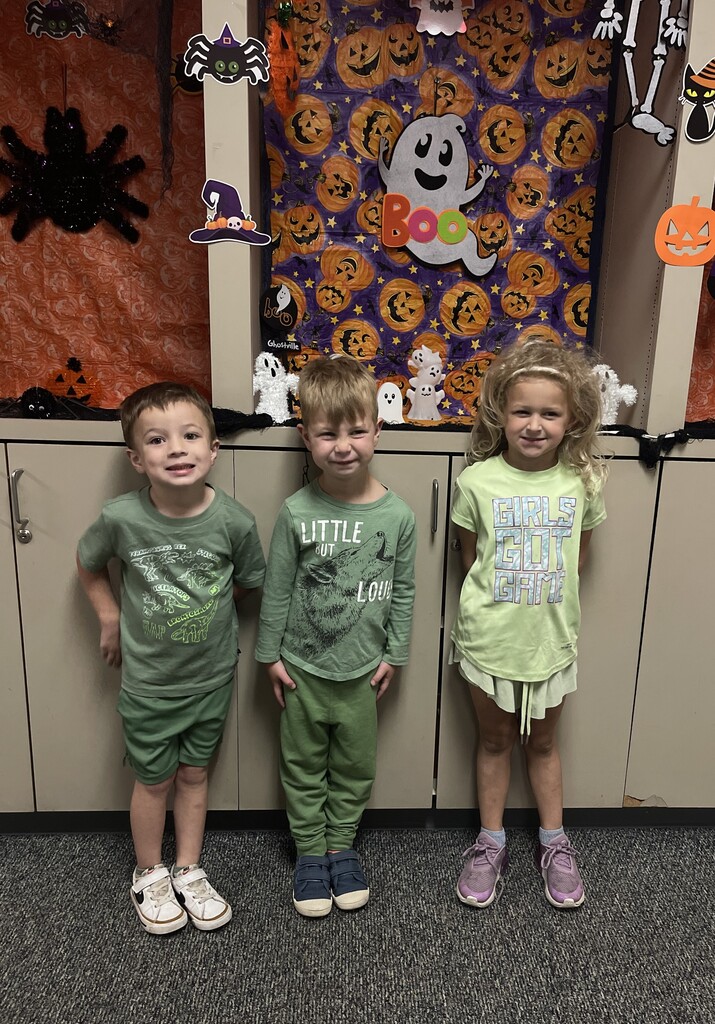 students wearing green and smiling