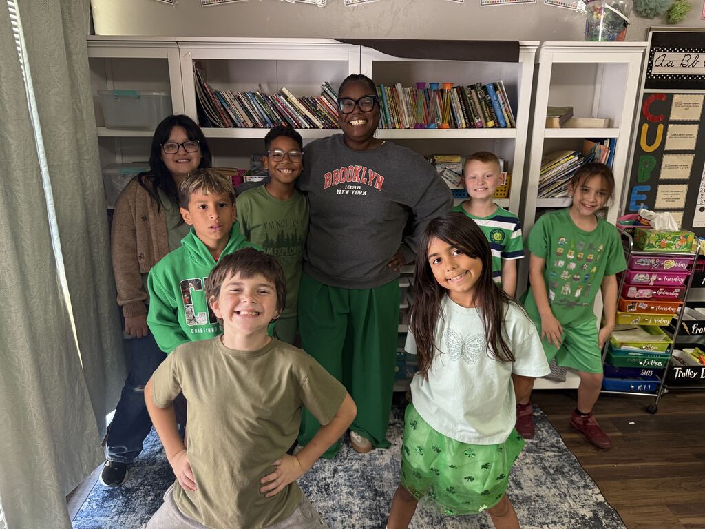 7 students and a staff member all wearing green