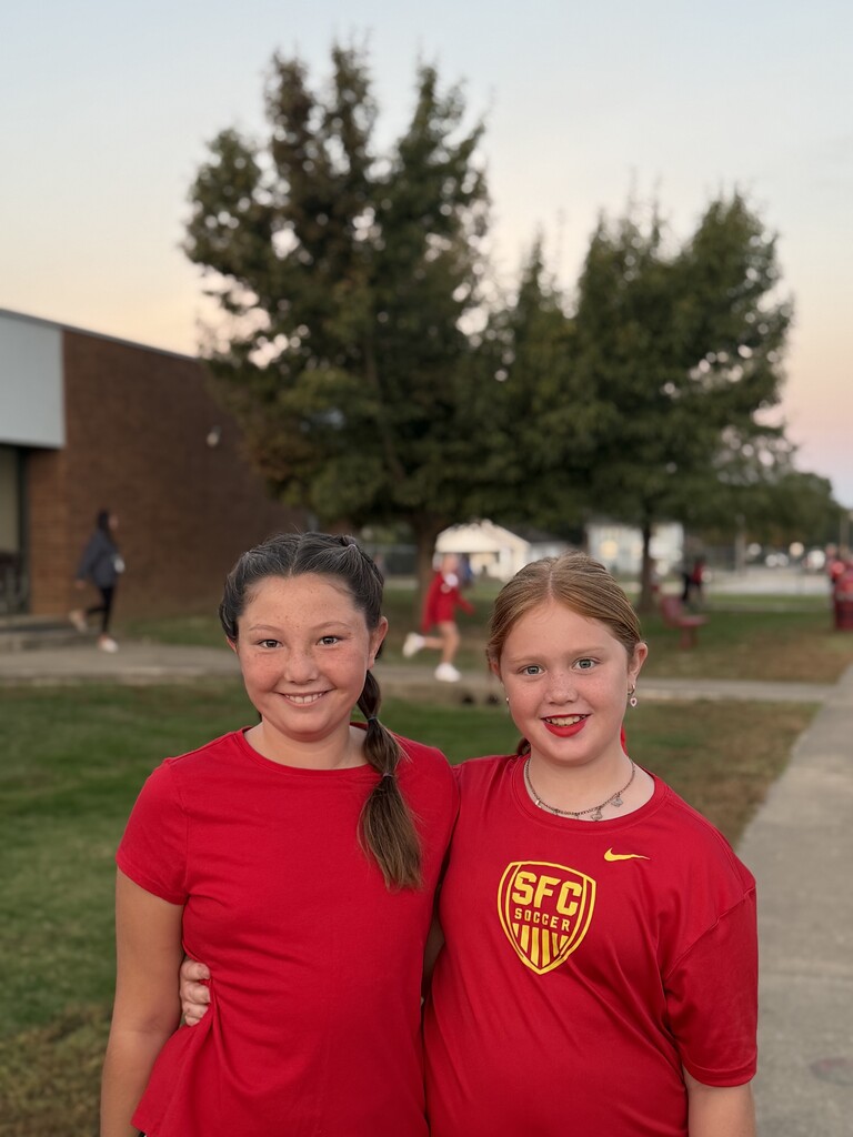 students smiling wearing all red