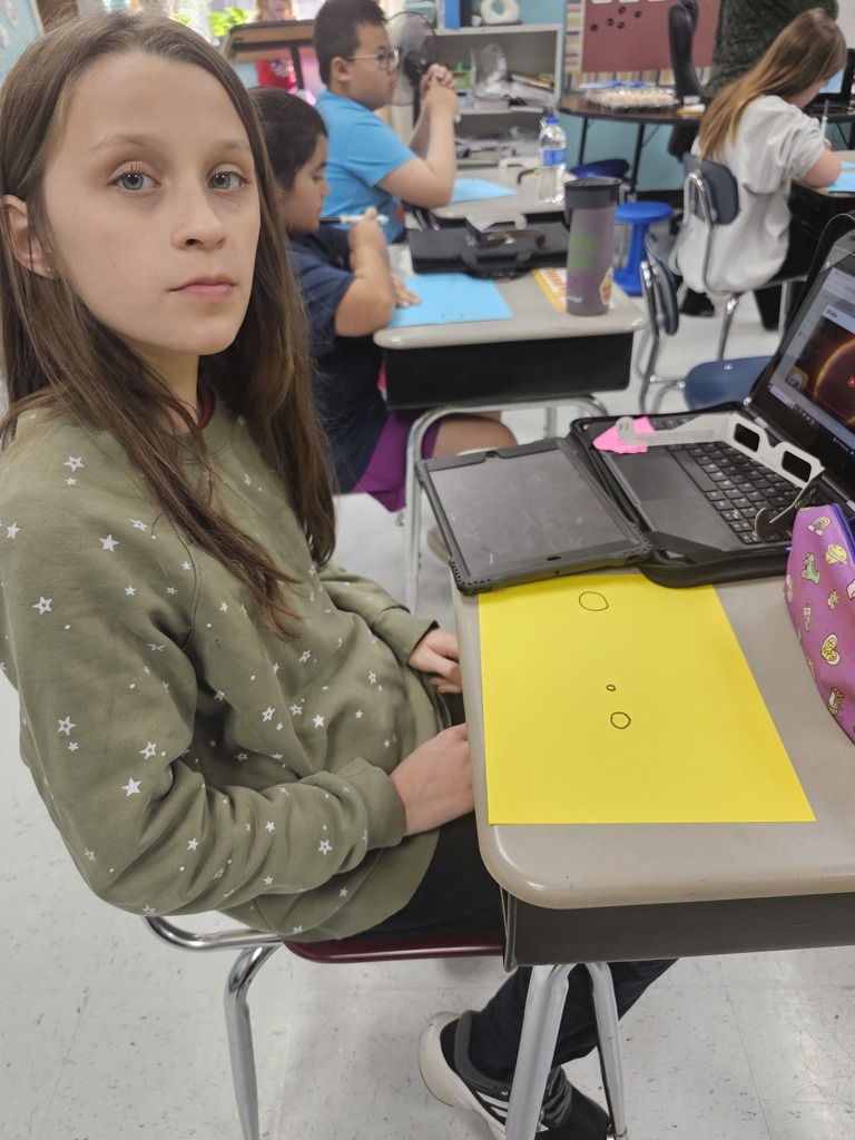 student creating drawing of sun, moon and earth