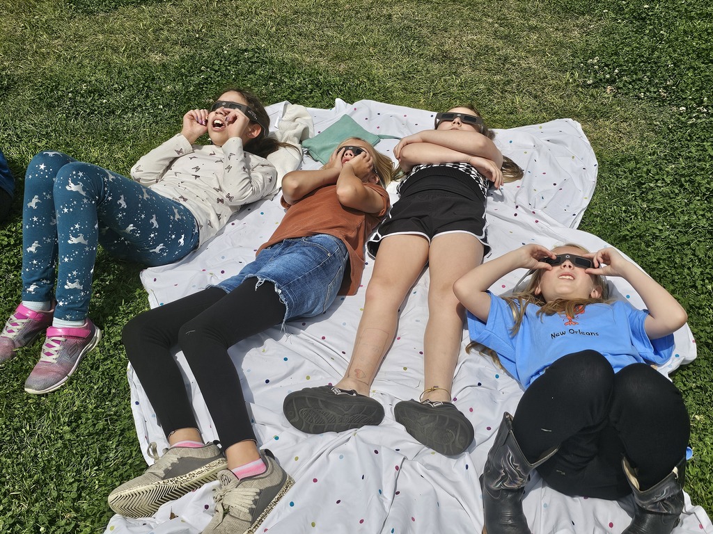 Students in eclipse glasses making observations about the sun