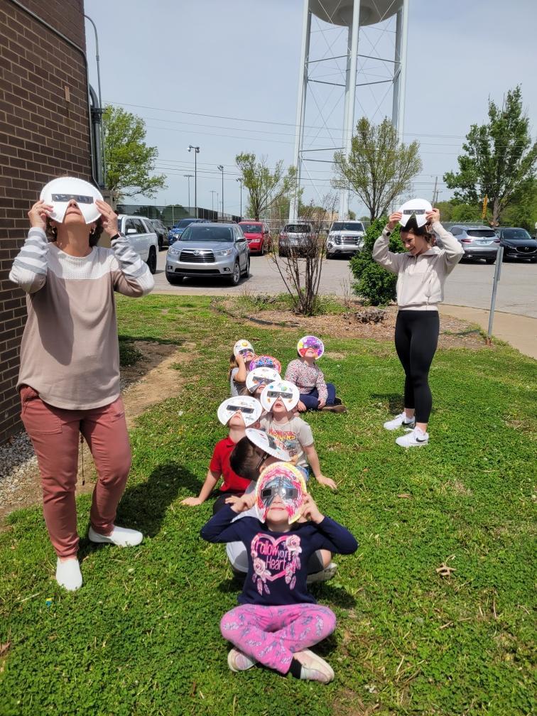 PreK students in eclipse glasses/mask watching the eclipse