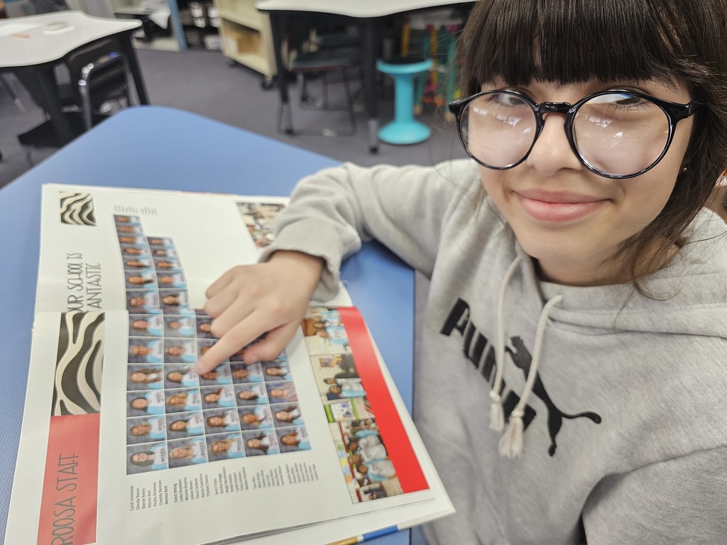 Student pointing out favorite teachers in old yearbook