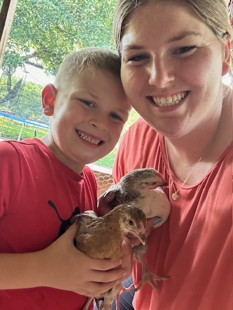 Mrs. Hamilton and her son holding chickens
