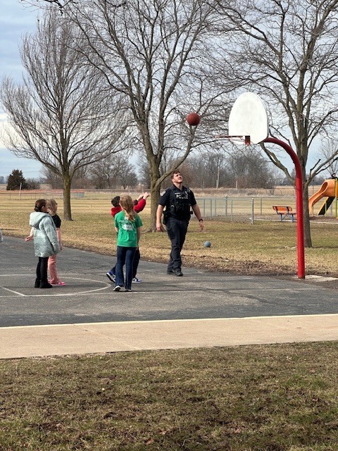 Officer Holderfield playing basketball with our CES students.