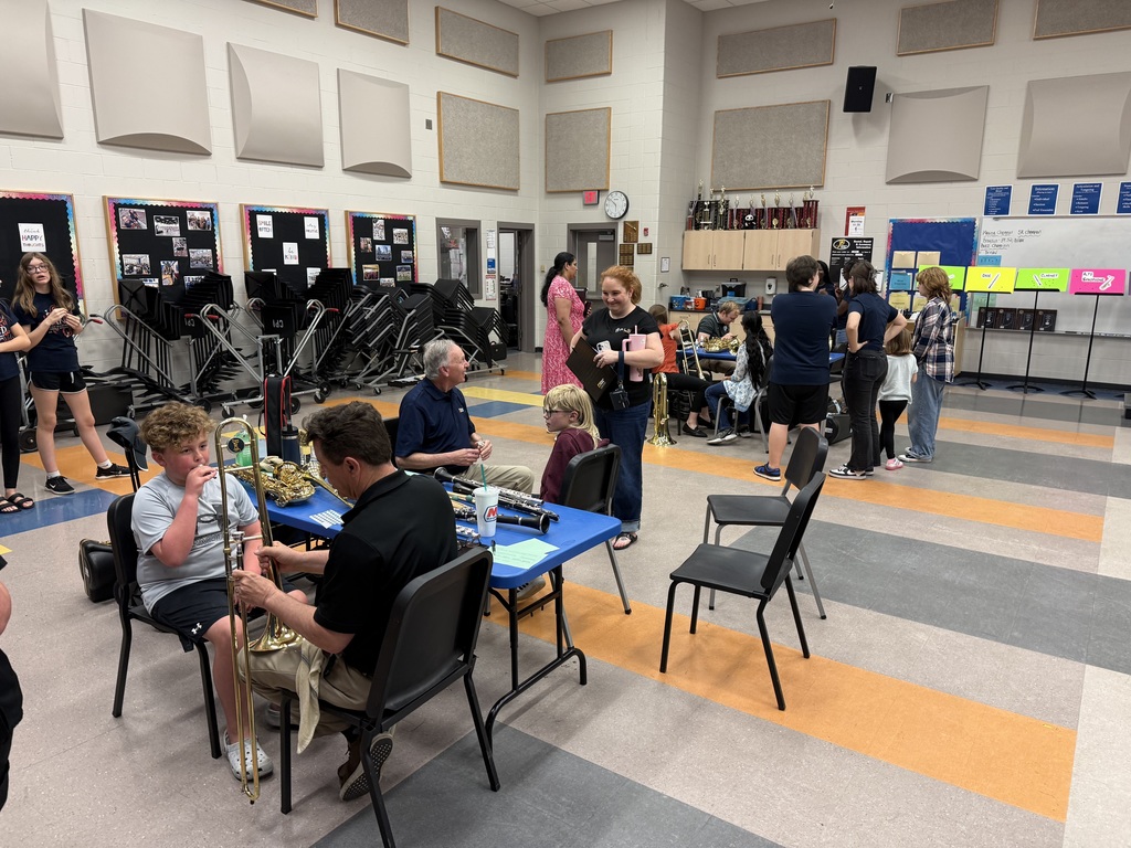 BAND ROOM full of students trying instruments 