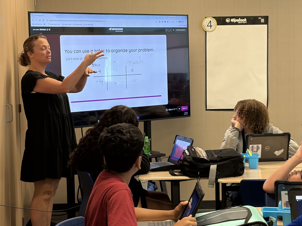 teacher teaching with students at computers