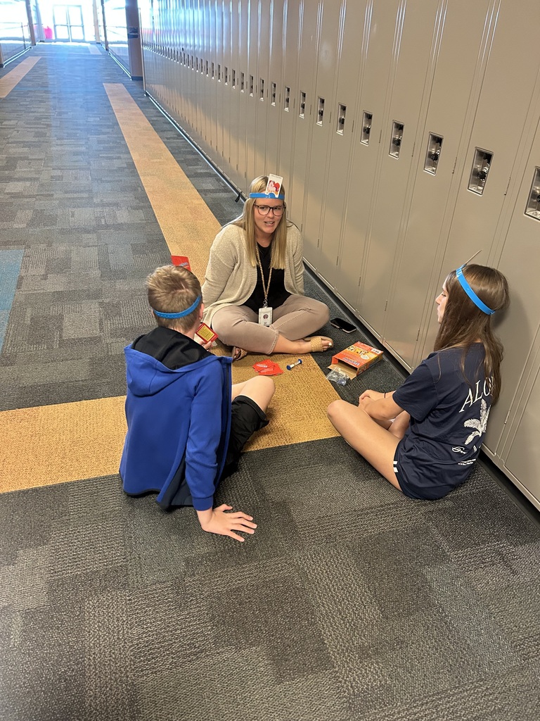 students and teacher playing card game