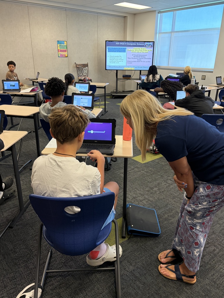 teacher helping student at computer