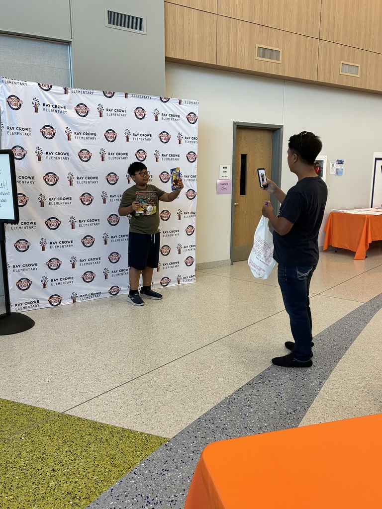 Parent taking picture of student with book