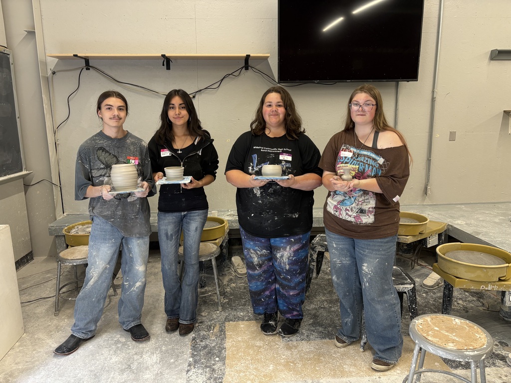four students with their pottery