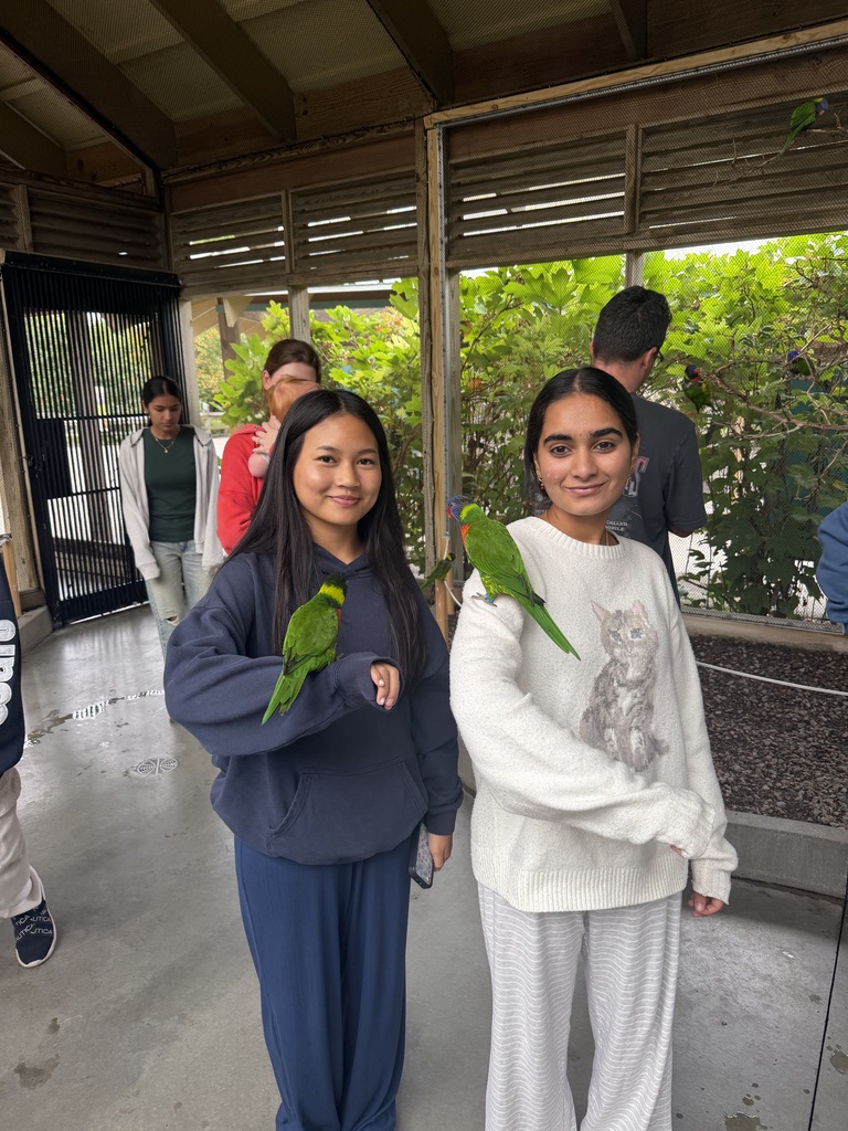 girls at zoo with birds on arms