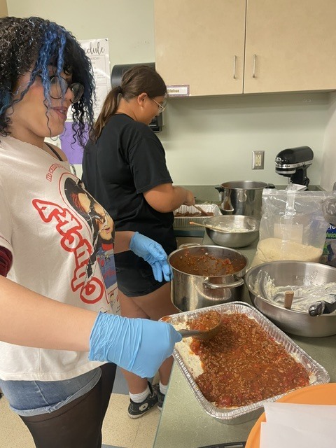 students putting together lasagna