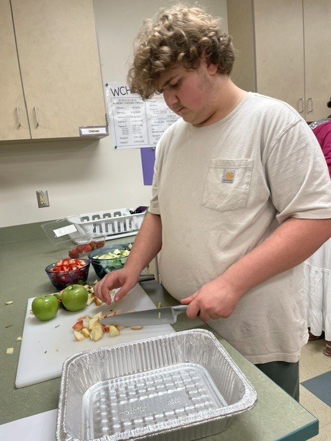 student chopping food