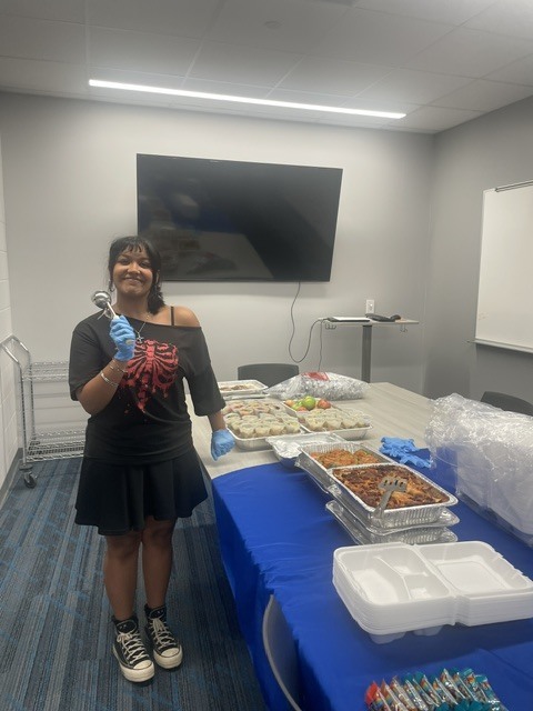 student setting up food for teachers