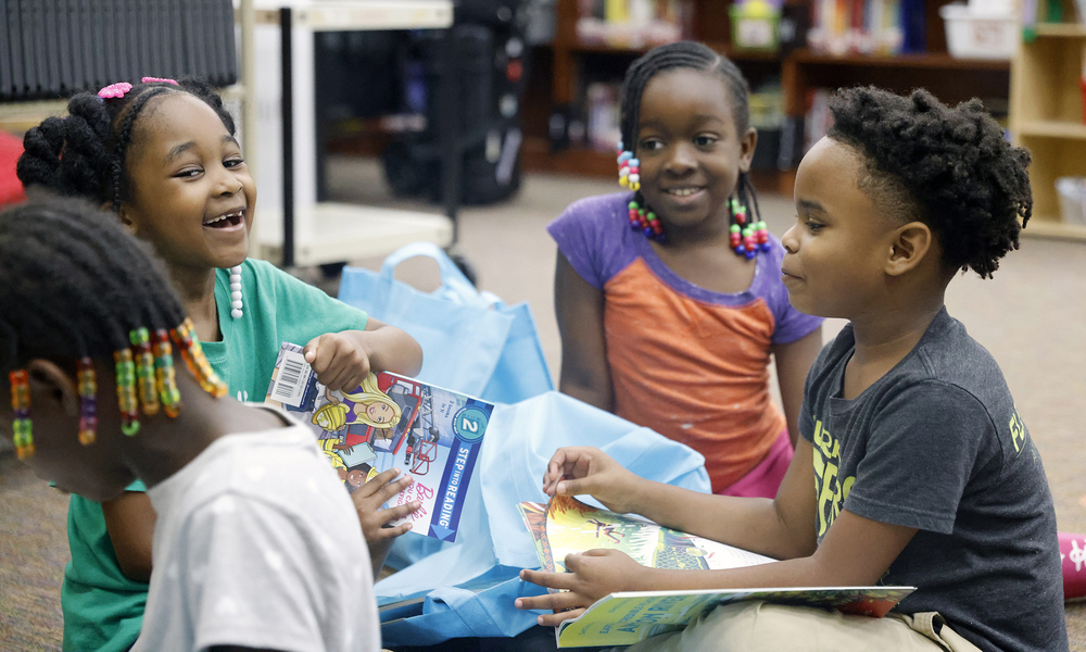 Students with books laughing and smiling