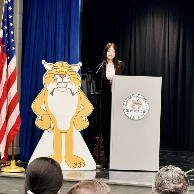 a woman in a black suit addresses the crowd