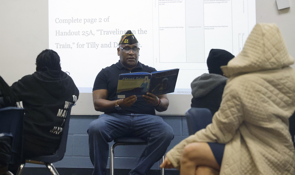 Man reading to students