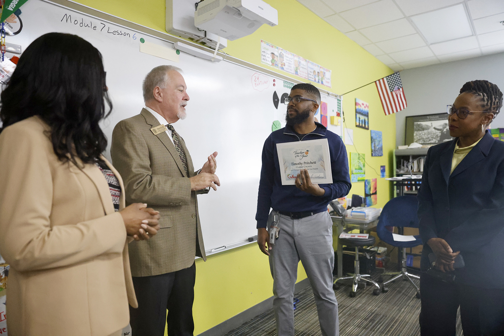 Woods speaking with Pritchett and school and district leaders