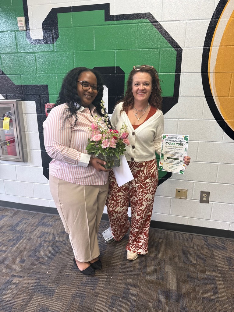 Ms. Colquitte (bookkeeper and registrar) pictured next to Ms. Navarette (front desk receptionist) with flowers and their lunch certificate