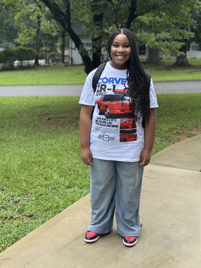 An image of our BHL 2026 graduate, Maleeyah Gates. She is standing in front of a tree with green grass along a street.