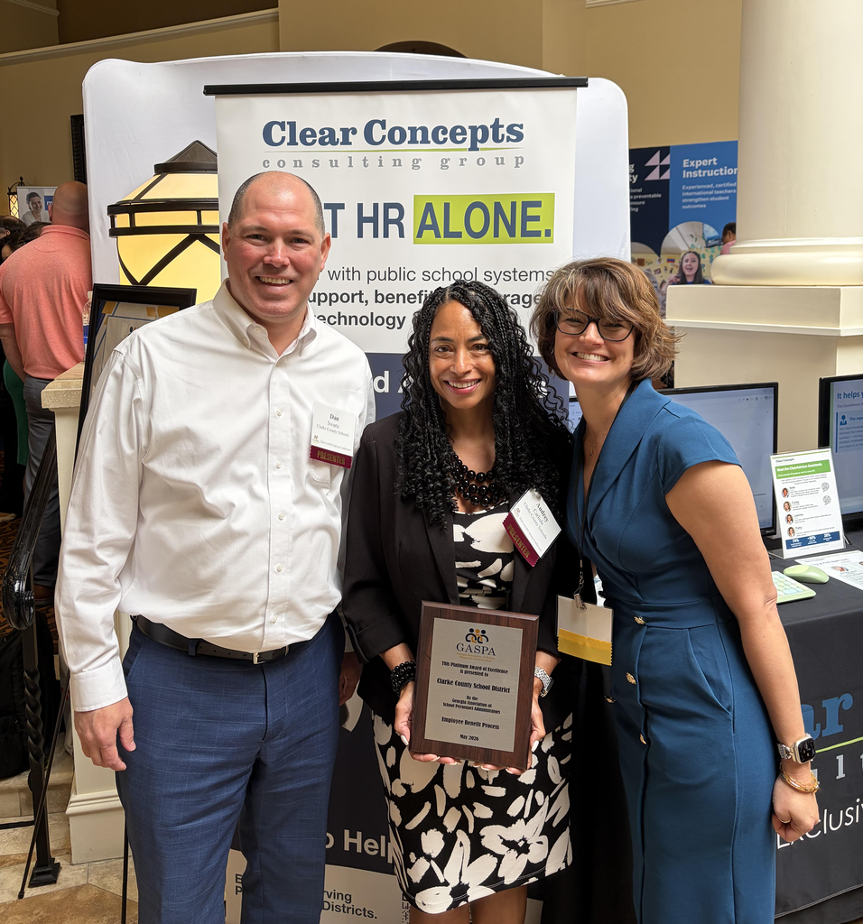 Three people smiling with award