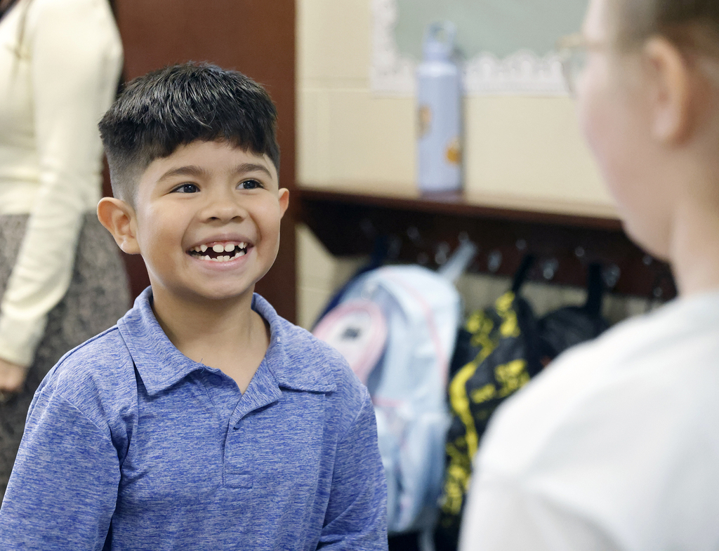 Student smiling while talking with other student