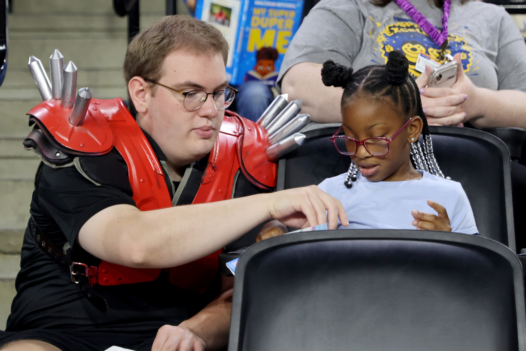 Student reading book with member of UGA Spike Squad