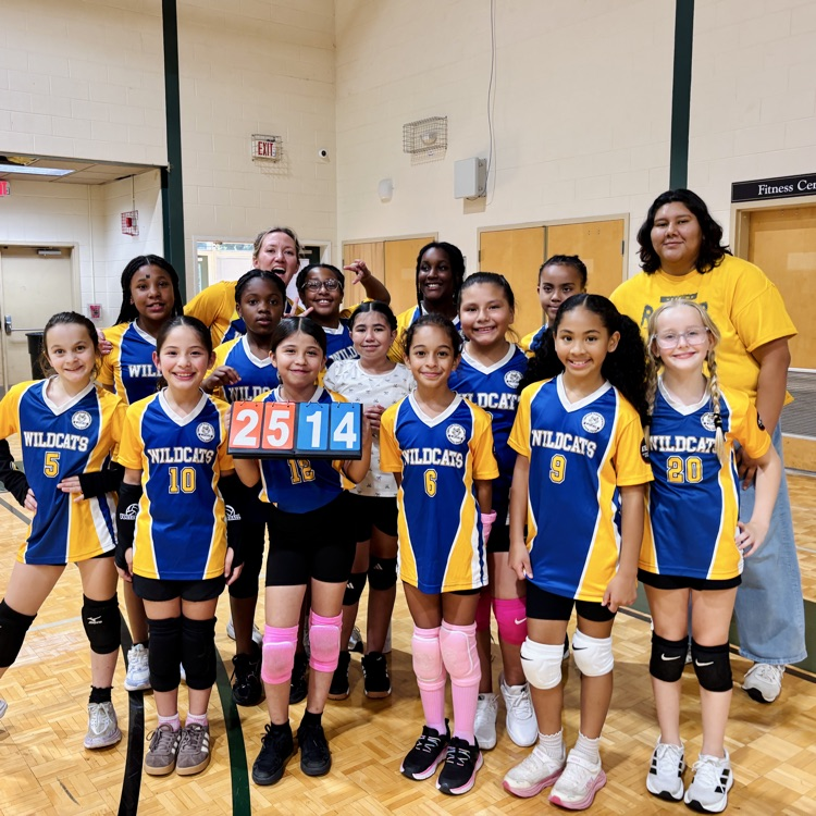 a team of volleyball players holds up the winning score