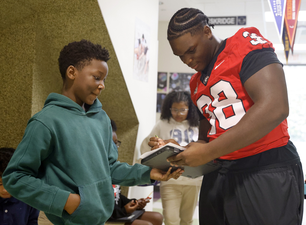 AJ Lonon signing autograph for student