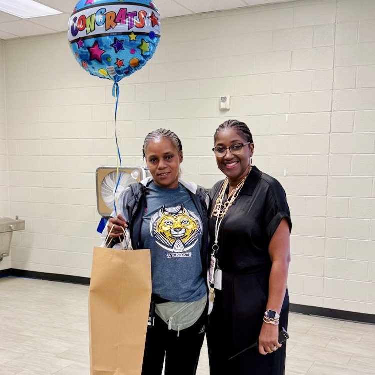 Erica Taylor, SPOTY, stands with a balloon and gift alongside Ms. Boles