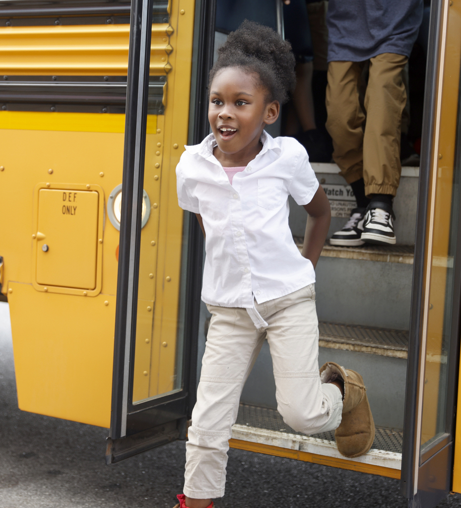 Student stepping off bus excitedly