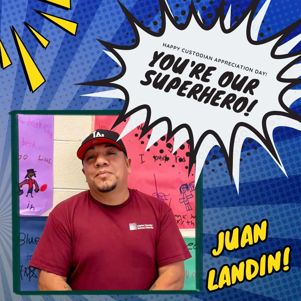Mr. Juan poses smiling in front of student artwork