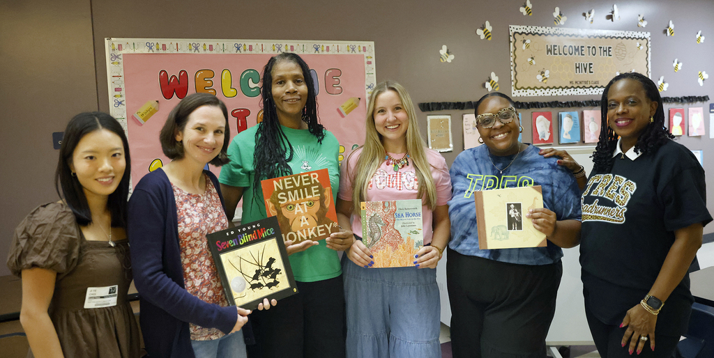 Teachers posing while holding books