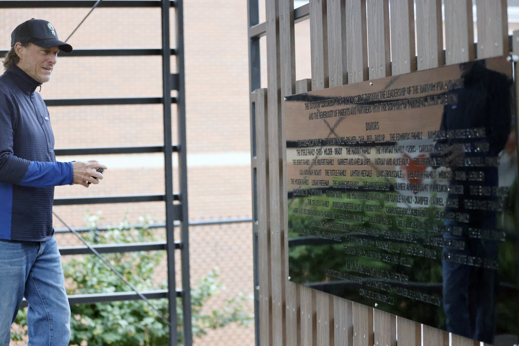 Man looking at wall of donors