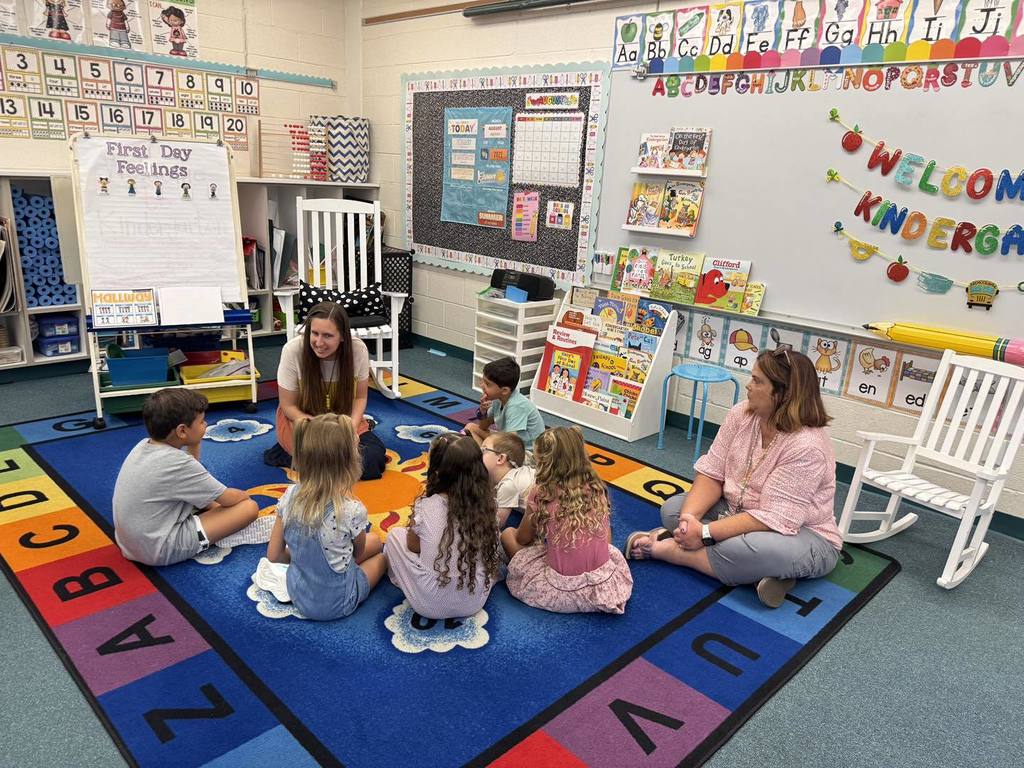 Students sitting on rug in kindergarten class