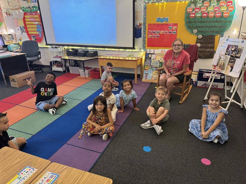 Students sitting on rug in kindergarten class