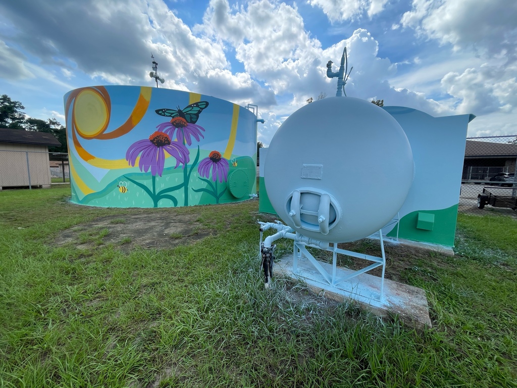 image of a water tank with flowers and butterfly painted on the side.