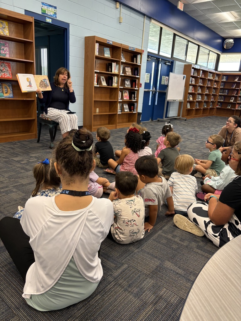 Media Specialist Ms. Pittman reading We Don’t Eat Our Classmates aloud to a group of Little Paws preschoolers.