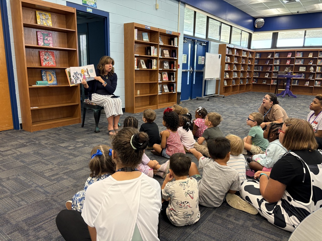 Media Specialist Ms. Pittman reading We Don’t Eat Our Classmates aloud to a group of Little Paws preschoolers.