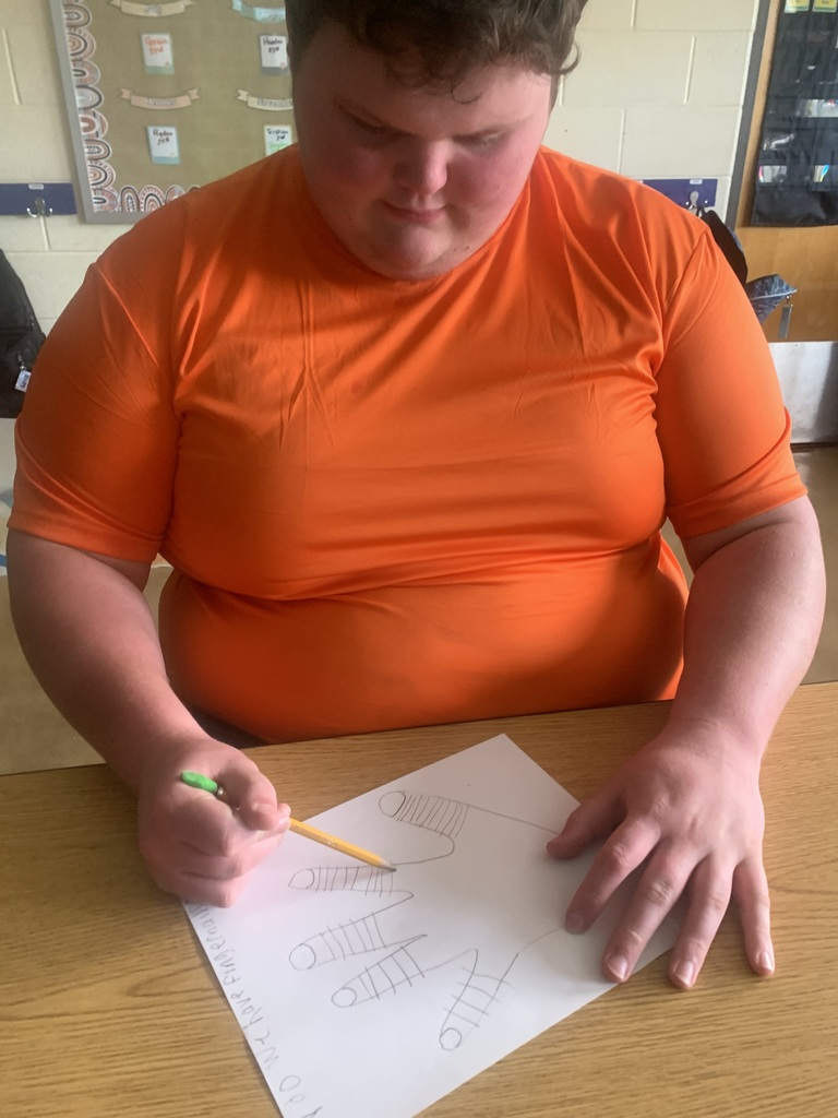 Student closely examining their hand while beginning Step 1 of the scientific method.