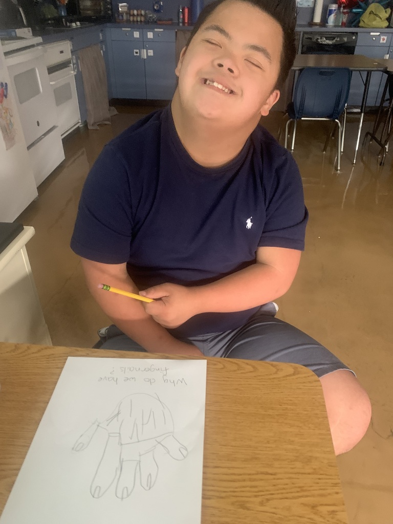 Student closely examining their hand while beginning Step 1 of the scientific method.