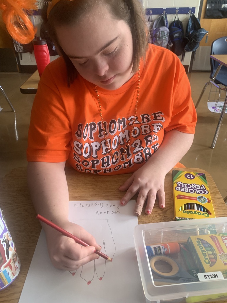 Student closely examining their hand while beginning Step 1 of the scientific method.