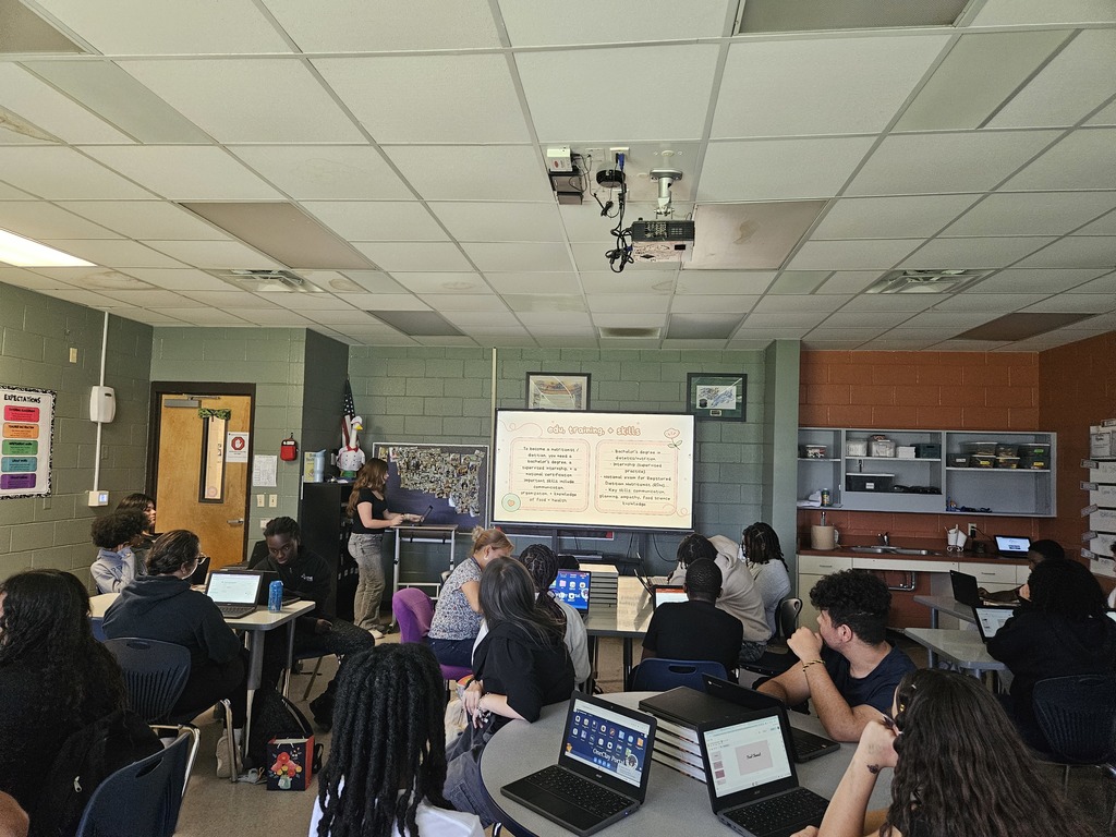 Student presenting research on a culinary career pathway while classmates listen.