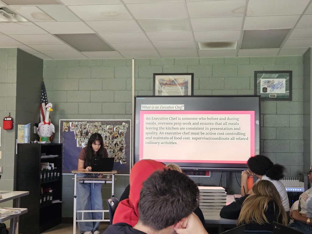 Student presenting research on a culinary career pathway while classmates listen.