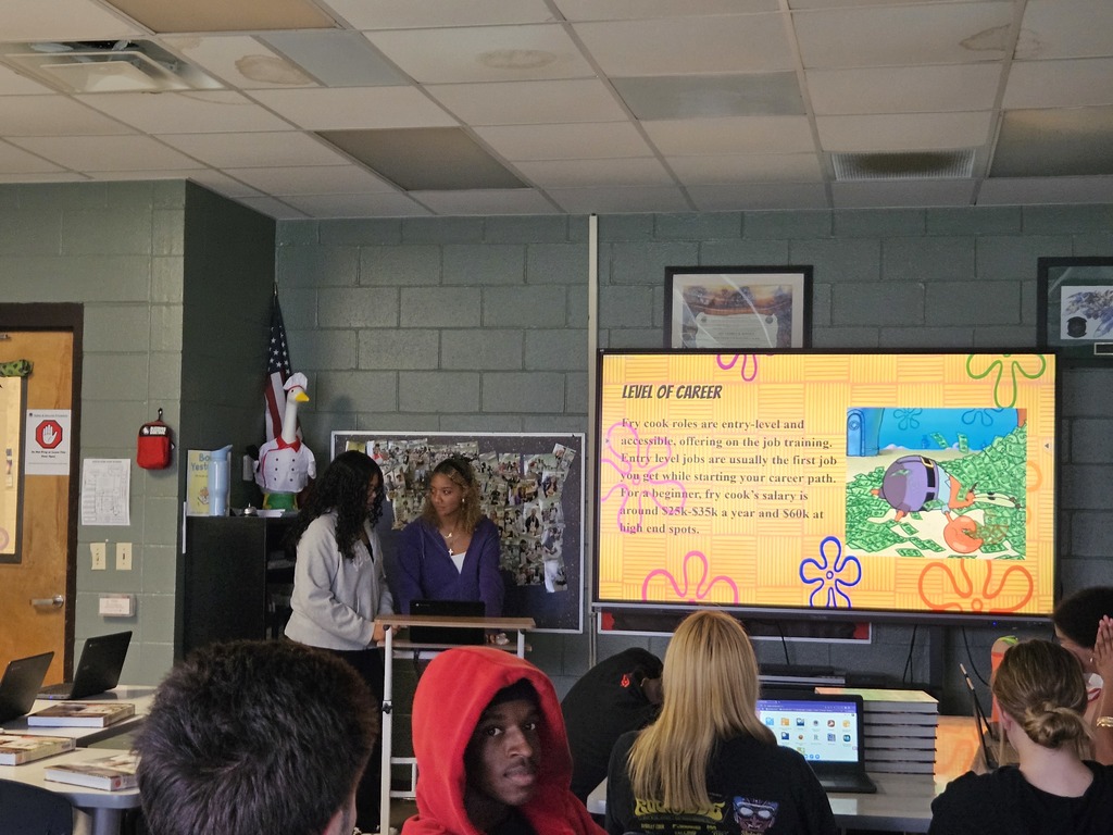 Student presenting research on a culinary career pathway while classmates listen.