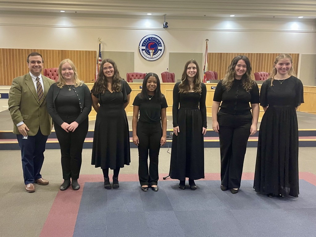 Six female students who are members of FIHS chorus standing with their teacher Mr. Normon