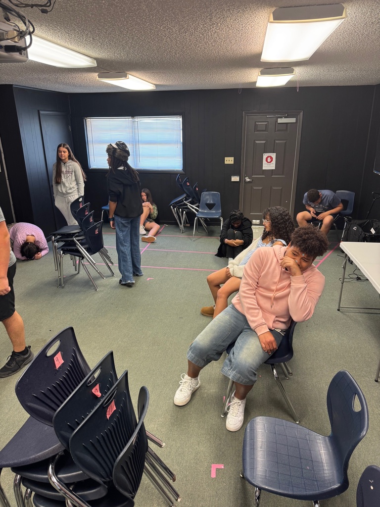 Theatre students spread out around the classroom, walking slowly while preparing to act out emotional prompts.